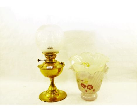 A brass oil lamp with etched globe plus two glass shades