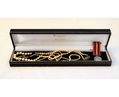 Two pearl necklaces, both with small white metal clasps set with diamonds plus a small WWII miniature medal