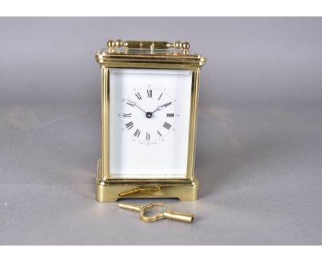 A modern brass repeater carriage clock, white face, Roman numerals, 15 cm high  