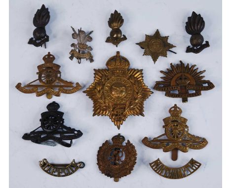 A small collection of metal insignia, to include a Royal Marines helmet plate, cap badges for the Royal Artillery x3, Royal E
