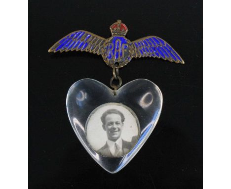 A WW II brass and enamelled R.A.F. sweetheart wing brooch, suspending a heart shaped perspex pendant containing a portrait of