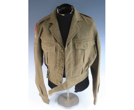 A post WW II 1949 pattern battle dress blouse, with cloth shoulder titles and Lance Corporal rank stripe, dated 1954 size 13.