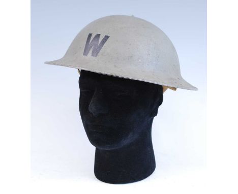 A WW II British Home Front Wardens steel helmet with stencilled W to the front, having a leather liner and canvas chin strap.