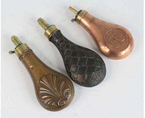 A Victorian copper powder flask, of typical pear shape with embossed shell decoration, the brass nozzle measuring 1 1/4 to 3 