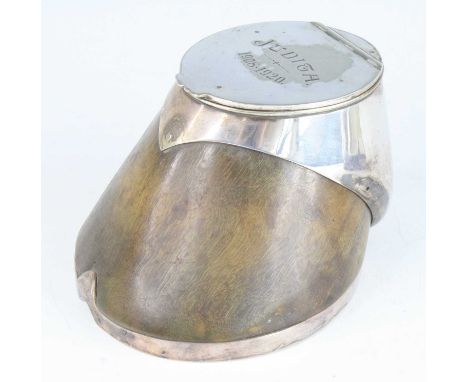 A George V horse hoof inkwell, having a silver plated horse shoe mount and hinged lid with interior glass well, inscribed Jud