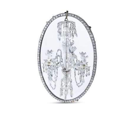 AN IRISH GEORGE III OVAL MIRRORthe frame set with clear glass studs and hung with a two-light cut crystal sconce. 52cm wide; 