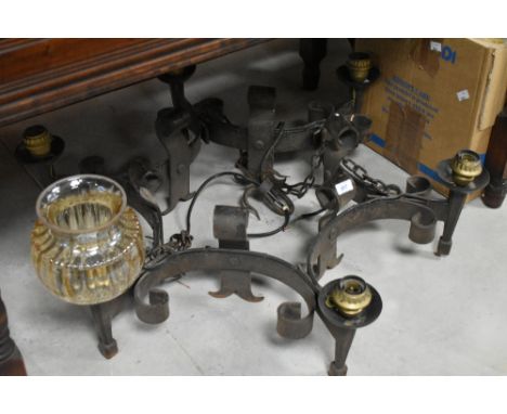 A cast iron electric ceiling light fitting in the medieval chandelier style, with glass shades