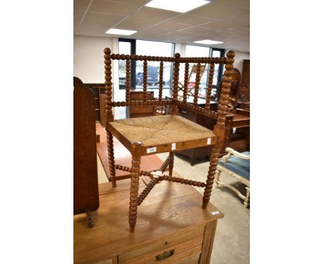 A Victorian corner chair having bobbin turned frame and strung seat
