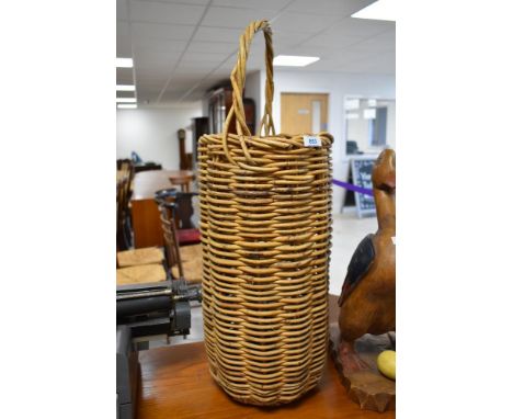 A tall wicker umbrella or stick stand style basket