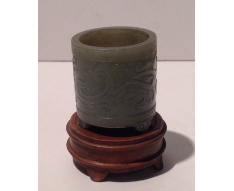 AN ANTIQUE CHINESE PALE GREEN JADE JAR Carved with a dragon within a Greek Key border, raised on a hardwood stand.  (4.8cm x 