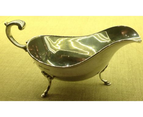 JOSEPH RODGERS, SHEFFIELD, 1899, A HALLMARKED SILVER SAUCE BOAT Along with a trefoil pattern hallmarked silver three pronged 