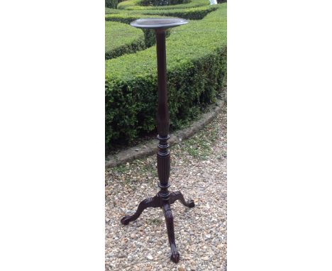 A REGENCY STYLE MAHOGANY TORCHÈRE The turned and reeded column standing on three acanthus carved splayed legs, terminating on