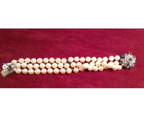 A 20TH CENTURY CULTURED PEARL, SAPPHIRE AND DIAMOND BRACELET Having three strands of pearls and a white metal star form clasp