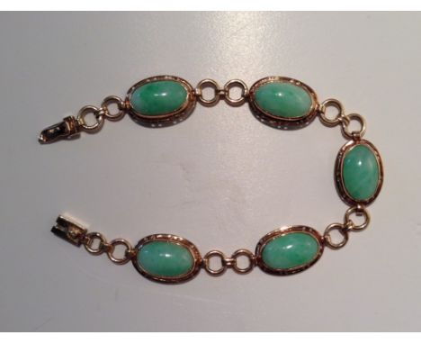 A 14CT GOLD AND OVAL JADE CABOCHON BRACELET  The clasp stamped '14k'. (21cm)