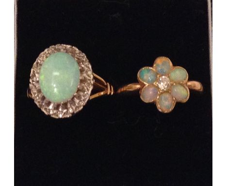 TWO 20TH CENTURY 18CT GOLD, OPAL AND DIAMOND RINGS The large cabochon cut central stone surrounded by diamonds, together with