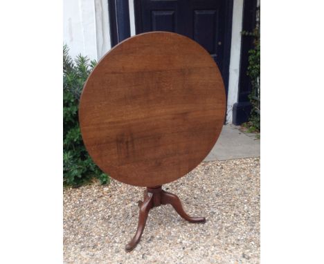 A GEORGE III PERIOD OAK TILT TOP SUPPER TABLE  The circular top raised on a turned column, with three splayed legs.