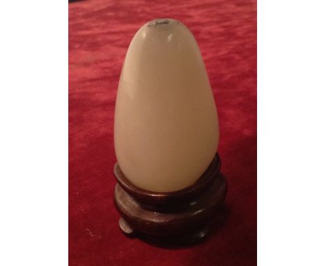 A FINE ANTIQUE WHITE JADE ROUNDED TRIANGULAR SECTION PENDANT Raised on a bespoke hardwood stand. (4cm x 2½cm) Condition: good