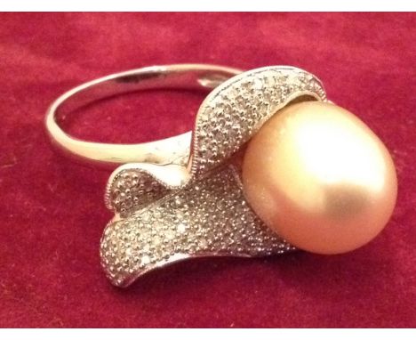 A 20TH CENTURY 14CT WHTE GOLD, DIAMOND AND PEARL RING  Having a large oval cultured pearl set within a pavé diamond encrusted