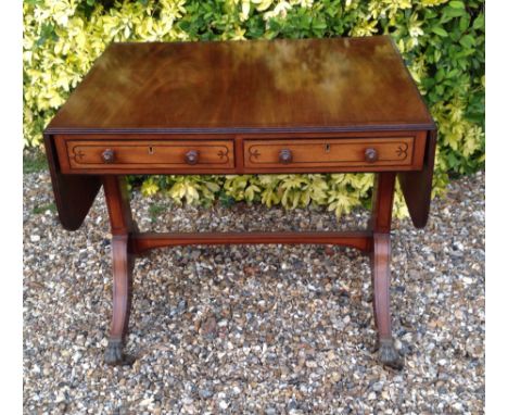 A REGENCY MAHOGANY AND EBONY LINE INLAID SOFA TABLE  With two drawers and raised on square columns, with splayed legs. 