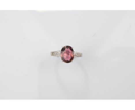 A certificated 9ct gold tourmaline and white topaz dress ring, the oval burgundy coloured mixed cut tourmaline in claw settin