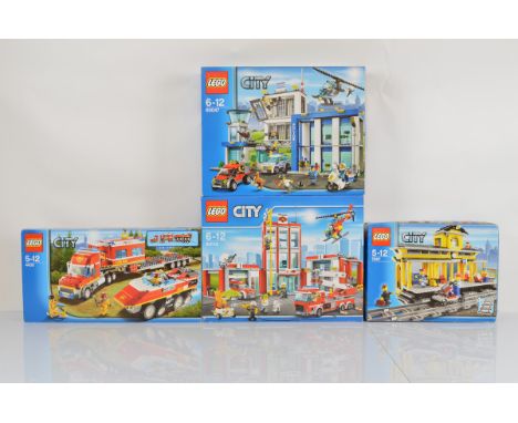 Four boxed Lego City models, including Fire Station 60110 unopened, Train Station 7997 opened with manual and unchecked, Fire
