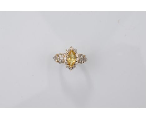 A certificated 18ct gold yellow beryl and diamond dress ring, the marquise cut yellow beryl with chevron setting to either en