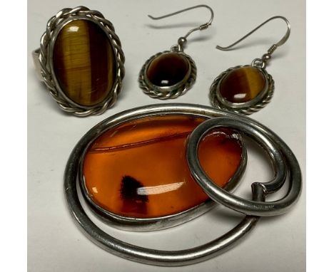 A silver coloured metal and amber set brooch; a silver coloured metal tigers eye ring and earrings (4) 