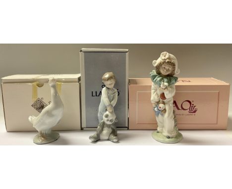 A Lladro figure, boy with panda toy, First Discoveries, 14cm, number 101.06974, boxed; a Nao figure, Nina Harlequin Con Palom