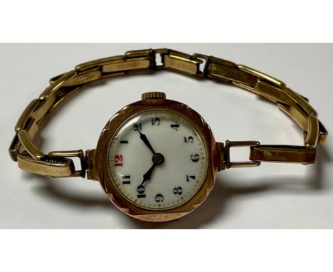 A 9ct gold lady's wristwatch, circular white enamel dial, Arabic numerals, side wind, articulating bracelet 