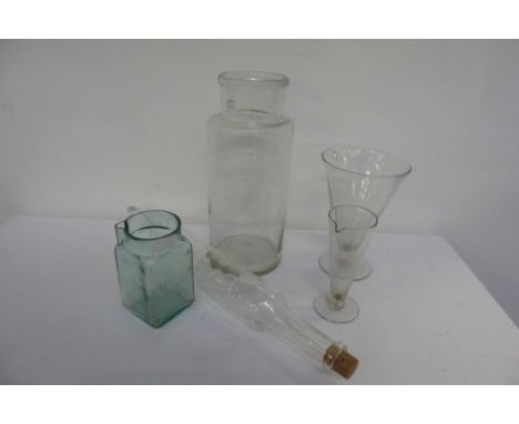 A glass rolling pin, a glass jar, with three other pieces of glass