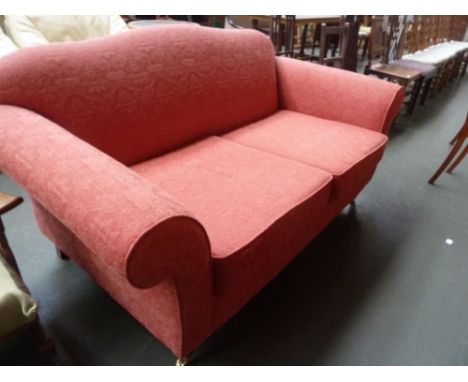 A 20th century red sofa, foliate-scroll throughout, raised on turned legs and castors