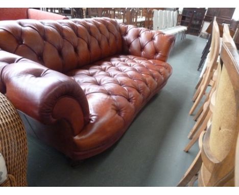 A 20th century leather Chesterfield sofa, raised on pilastered vase feet, 225W