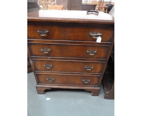 A 20th century small mahogany four drawer chest, raised on carved bracket feet