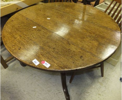 An early 19th Century oak tea table, the circular snap top on a turned pedestal to tripod base