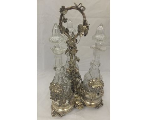 A plated and cut glass decanter set in the manner of Henry Elkington, comprising three cut glass decanters and stoppers with 