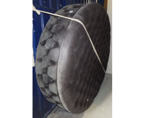 An over-sized buttoned leather upholstered circular stool / pouffe