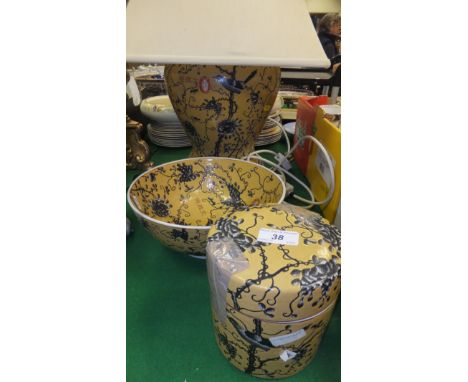 A Chinese table lamp decorated in black and white with birds amongst branches, on a yellow ground and bearing script, togethe