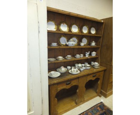 A 19th Century Irish pine dresser, the three tier boarded plate rack over two drawers and pot shelf