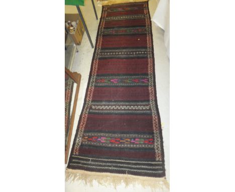 A Kelim runner with striped decoration in aubergine and black within a cream geometric patterned border, 285 cm x 84 cm