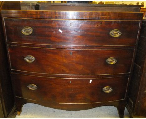 An early 19th Century mahogany bow fronted chest, the cross-banded top above three long drawers on bracket feet
