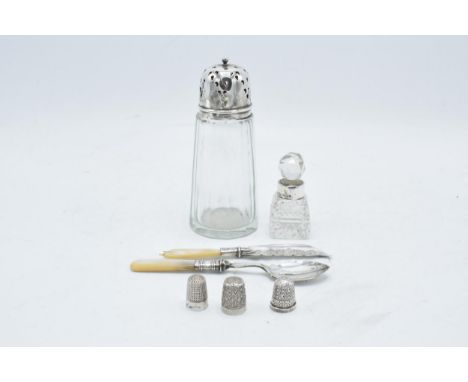 A collection of silver items to include a silver topped shaker, a perfume bottle with a silver neck, 3 silver thimbles (1 con