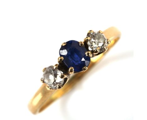 An 18ct gold three stone sapphire and diamond ring, set with oval mixed-cut sapphire and old-cut diamonds, sapphire measures: