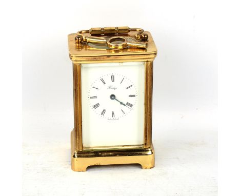 A brass-cased carriage clock, by Henley, white enamel dial with Roman numeral hour markers and blued steel hands, case height