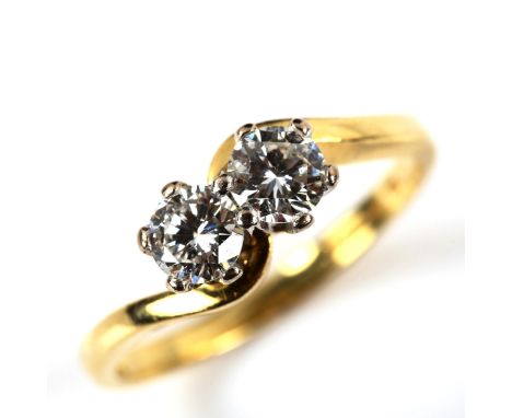 An 18ct gold two stone diamond crossover ring, set with modern round brilliant-cut diamonds, total diamond content approx 0.5