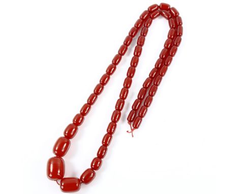 A graduated single-strand cherry red amber barrel bead necklace, bead lengths 26.6mm to 15.2mm, necklace length 88cm, 87.6gNo