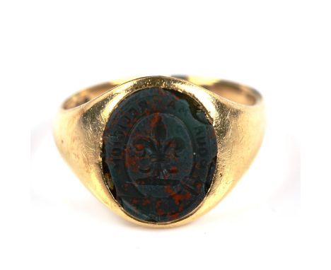 An early 20th century 18ct gold bloodstone seal signet ring, intaglio carved with fleur de lis and garter emblem with motto "