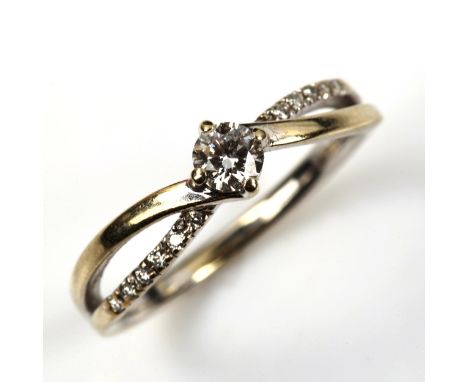 A modern 18ct white gold 0.2ct solitaire diamond crossover ring, with diamond set shoulders, size L, 2.8gNo damage or repairs
