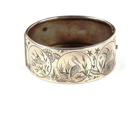A Victorian sterling silver chinoiserie style hinged bangle, engraved bird decoration, band width 26.1mm, internal measuremen