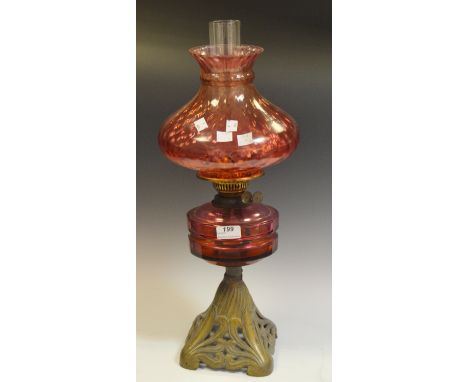A Victorian  lamp, cranberry glass shade and reservoir, pierced gilt metal stand, c.1900
