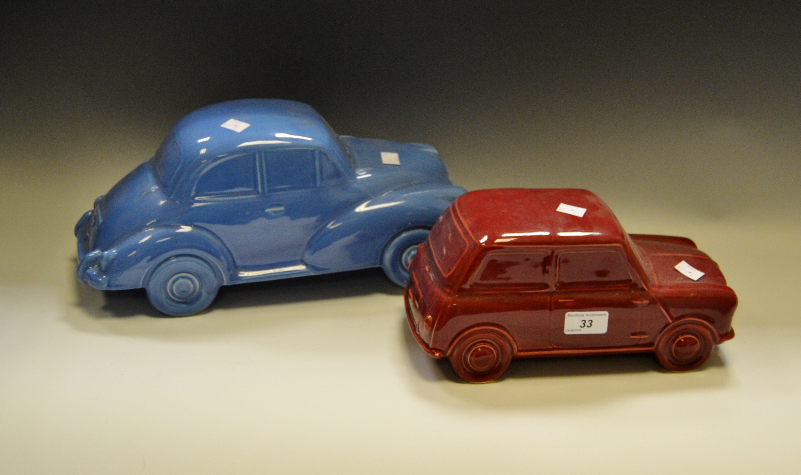 Decorative Ceramics a pottery model of a Mini car, glazed in puce; another of a Morris Minor ca